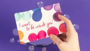 Hand holding a menstrual cup postcard that reads "I want to be inside you" — 5 Reasons Why My Menstrual Cup Is My Bestie
