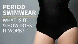 Grey background, woman wearing a black one-piece swimsuit. Text over reads, Period Swimwear What Is It And How Does It Work by Put A Cup In It
